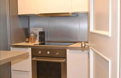 a kitchen with white cabinets and a stove top oven at Central Athenian Maison, with Acropolis Views in Athens