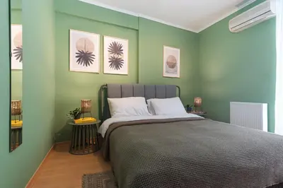 a bedroom with a large bed with green walls at Cozy Athenian Hideaway in the heart of Pangrati in Athens