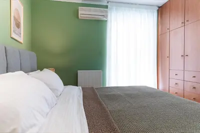 a bedroom with a bed with a green wall at Cozy Athenian Hideaway in the heart of Pangrati in Athens