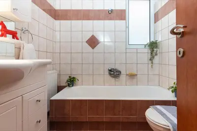 a bathroom with a tub and a toilet and a sink at Cozy Athenian Hideaway in the heart of Pangrati in Athens