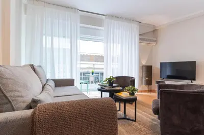 a living room with a couch and a flat screen tv at Cozy Athenian Hideaway in the heart of Pangrati in Athens