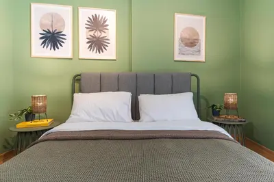a bedroom with a bed with three pictures on the wall at Cozy Athenian Hideaway in the heart of Pangrati in Athens