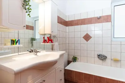 a bathroom with a sink and a tub and a mirror at Cozy Athenian Hideaway in the heart of Pangrati in Athens