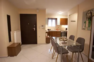 a dining room and kitchen with a glass table and chairs at Lovely Nest Piraeus Premium in Piraeus