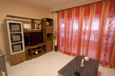 a living room with a large window and a television at Lovely Nest Piraeus Premium in Piraeus