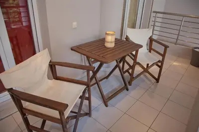 a small table and chairs with a cup on it at Lovely Nest Piraeus Premium in Piraeus