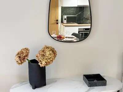 a mirror and a vase with flowers on a table at AirRent Apartments 4 Jacuzzi Suite in Athens