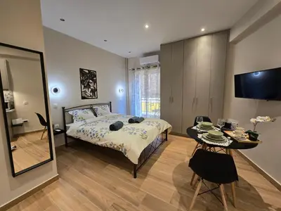 a bedroom with a bed and a table and a television at Dream Home Apartment by Metro in Athens