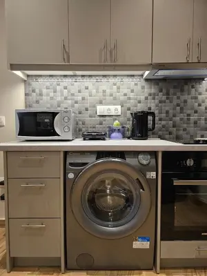 a kitchen with a washing machine and a microwave at Dream Home Apartment by Metro in Athens
