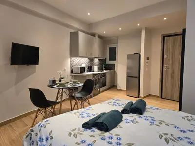 a bedroom with a bed and a kitchen with a table at Dream Home Apartment by Metro in Athens
