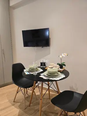 a dining room with a table with chairs and a tv at Dream Home Apartment by Metro in Athens