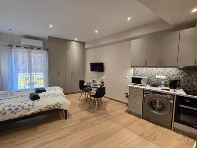 a bedroom with a bed and a kitchen with a table at Dream Home Apartment by Metro in Athens