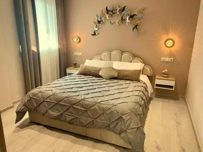 a bedroom with a large bed with a gray comforter at Mocha Luxury Residence in Spáta