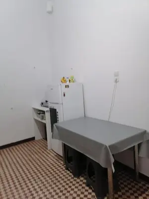a room with a table and a table and a refrigerator at Remoundou 18 rental room in Athens