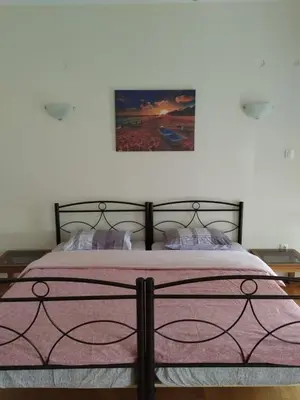 a bedroom with a large bed with a pink blanket at Remoundou 18 rental room in Athens
