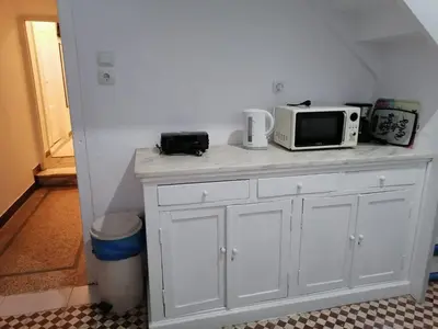 a white cabinet with a microwave on top of it at Remoundou 18 rental room in Athens