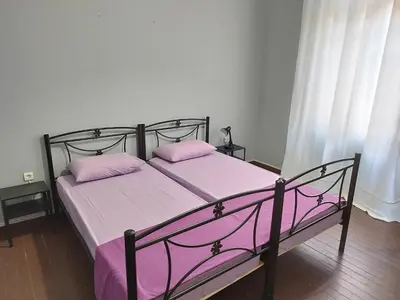 a bed with pink sheets and pillows in a bedroom at Remoundou 18 rental room in Athens