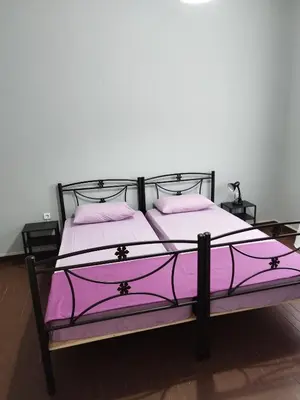 a bed with purple sheets and pillows in a room at Remoundou 18 rental room in Athens