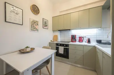 a kitchen with white cabinets and a white table at Athens F&K Premium City Home in Athens
