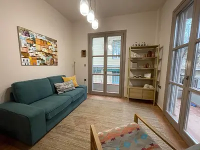 a living room with a blue couch and some windows at Chillout in Athens in Athens