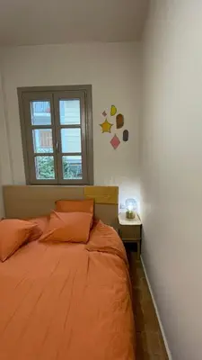 an orange bed in a bedroom with a window at Chillout in Athens in Athens