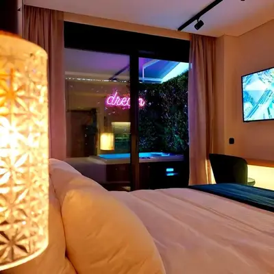 a bedroom with a bed and a window with a television at The Dream Suite in Piraeus