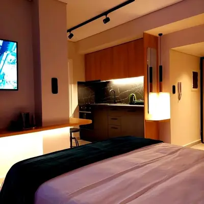 a bedroom with a bed and a kitchen at The Dream Suite in Piraeus