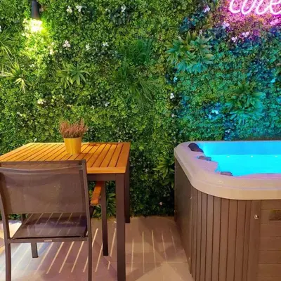 a garden with a table and a bath tub at The Dream Suite in Piraeus