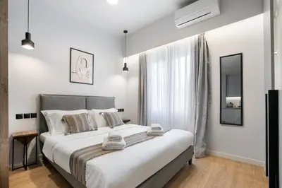 a bedroom with a large bed and a window at Avia Deluxe Studio - Athens Modern Escape in Athens