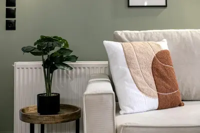 a plant on a table next to a white couch at Avia Deluxe Studio - Athens Modern Escape in Athens