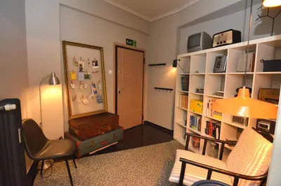a living room with a chair and a book shelf at Bibelot Acropolis in Athens
