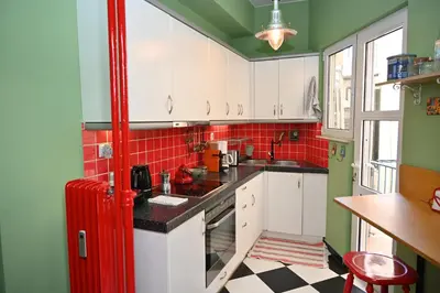 a kitchen with a red refrigerator and red tiles at Bibelot Acropolis in Athens