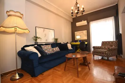 a living room with a blue couch and a table at Bibelot Acropolis in Athens