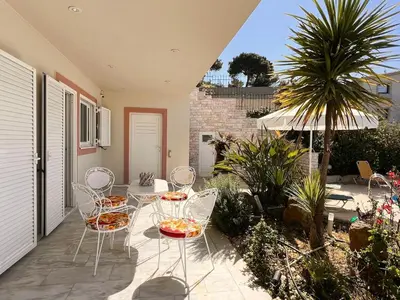 a patio with chairs and a table and an umbrella at Bella Vista pool Villas in Anavissos in Barbaliáki