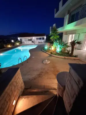 a swimming pool in front of a building at night at Bella Vista pool Villas in Anavissos in Barbaliáki
