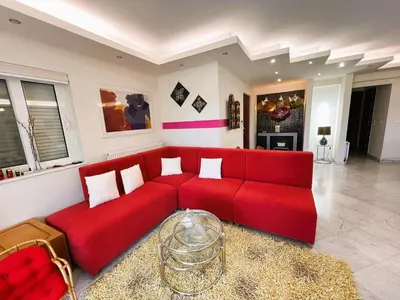 a living room with a red couch in a room at Bella Vista pool Villas in Anavissos in Barbaliáki