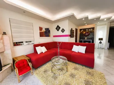 a living room with a red couch and a table at Bella Vista pool Villas in Anavissos in Barbaliáki