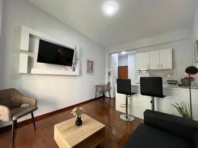 a living room with a couch and a tv on the wall at Charming Apartment in the center of Athens in Athens