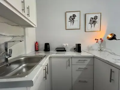 a white kitchen with a sink and a counter top at Charming Apartment in the center of Athens in Athens