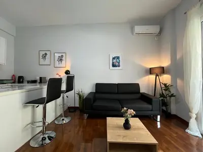 a living room with a black couch and a table at Charming Apartment in the center of Athens in Athens