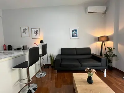 a living room with a black couch and a table at Charming Apartment in the center of Athens in Athens