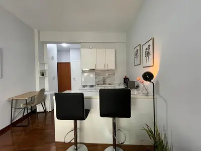 a kitchen with a counter and two chairs in it at Charming Apartment in the center of Athens in Athens