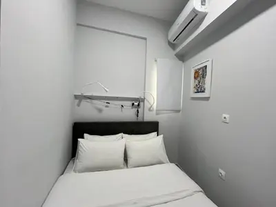 a white bedroom with a bed with white pillows at Charming Apartment in the center of Athens in Athens