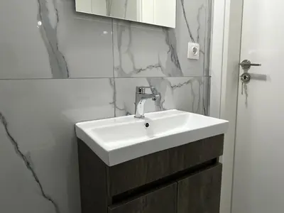 a bathroom with a white sink and marble walls at Charming Apartment in the center of Athens in Athens