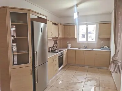 a kitchen with wooden cabinets and a stainless steel refrigerator at \u51ef\u5b81\u6c11\u5bbf in Piraeus