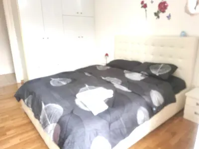 a bedroom with a bed with a black comforter at \u51ef\u5b81\u6c11\u5bbf in Piraeus