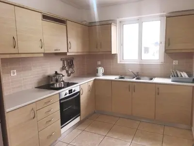 a kitchen with wooden cabinets and a stove top oven at \u51ef\u5b81\u6c11\u5bbf in Piraeus