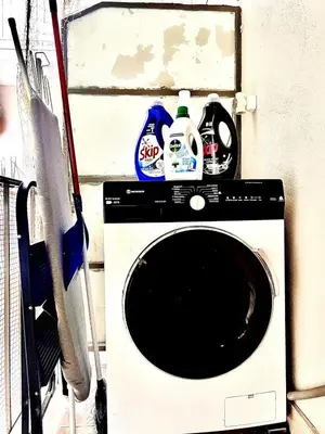 a washing machine with cleaning products on top of it at Couple Nest in Athens