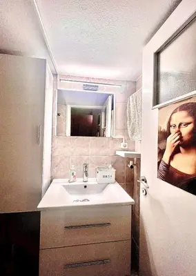 a bathroom with a sink and a picture of a woman at Couple Nest in Athens
