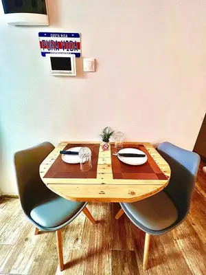 a wooden table with two chairs and a sign on the wall at Couple Nest in Athens